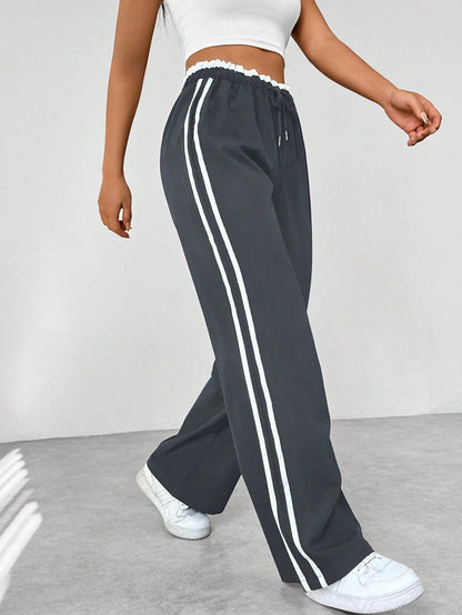 Close-up van de trendy strepen op deze sportieve wide-leg damesbroek, accentueert het streetwear design.