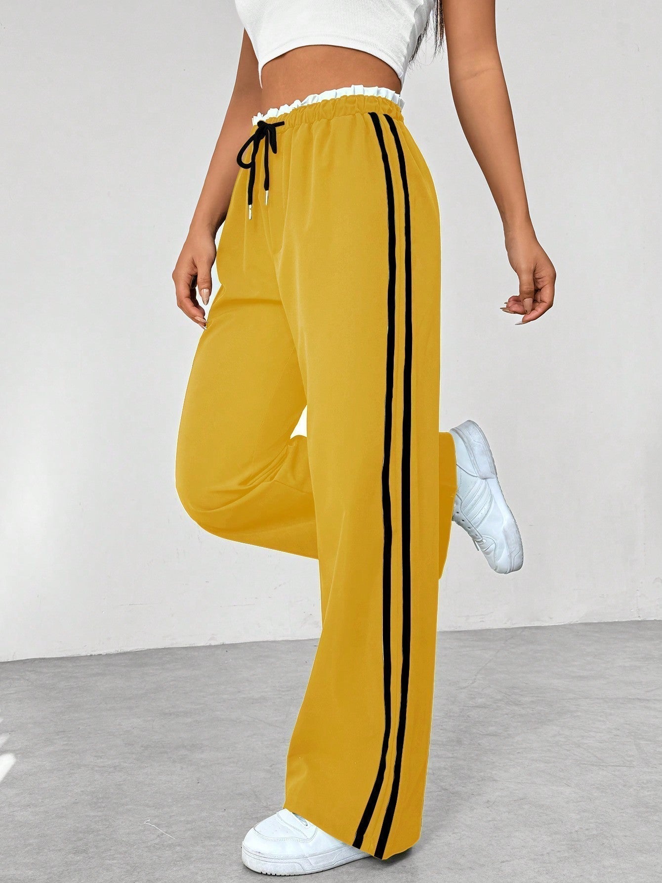 Vrouw draagt casual wide-leg damesbroek met strepen, perfect voor sportieve of relaxte looks.